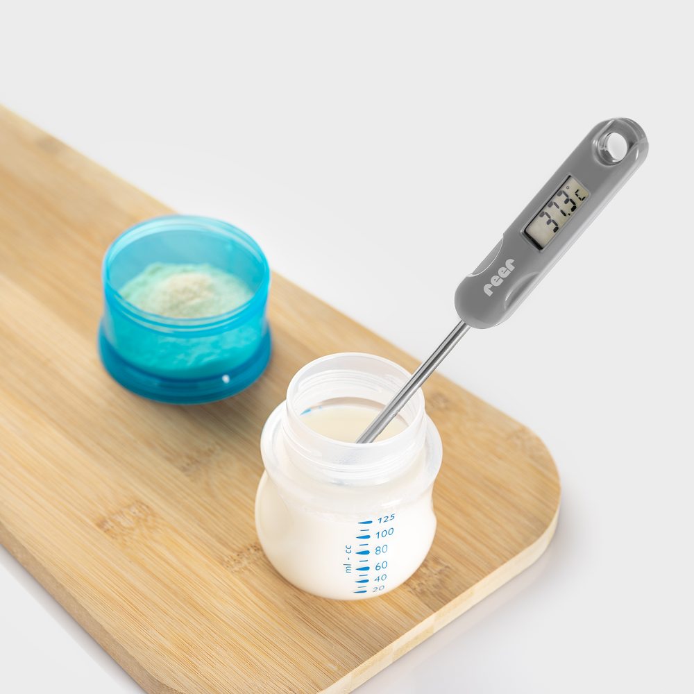 Pre-Milch wird mit einem Flaschen-Thermometer auf die richtige Temperatur von 37 Grad geprüft