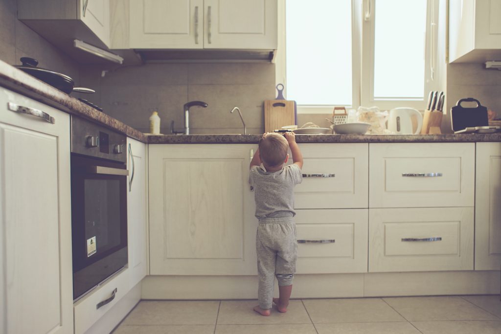 Kind kommt an die Küchenarbeitsplatte