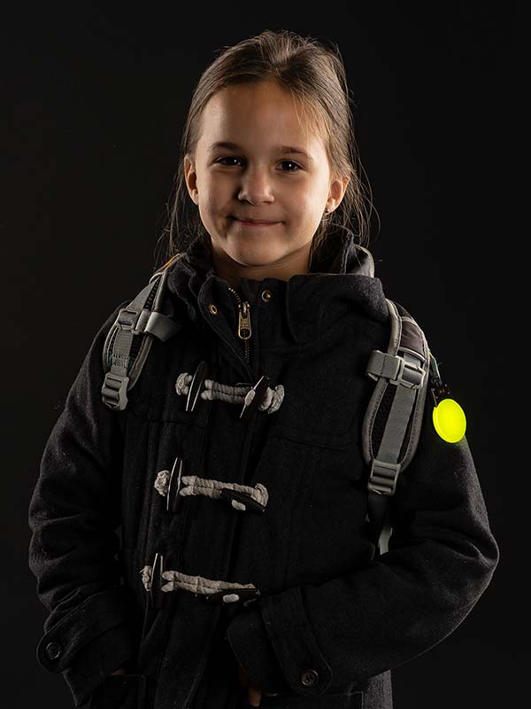 Kind trägt das Light&Go Sicherheitslicht, Blinklicht mit Karabinerhaken am Rucksack