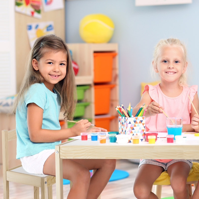 Zwei Kinder malen auf der PlayTime Kindersitzgruppe
