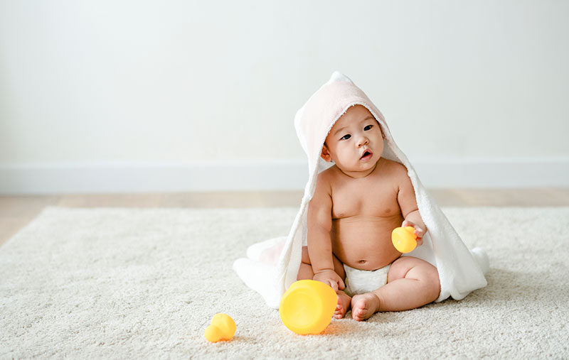 Baby spielt mit Bade-Quietschenten