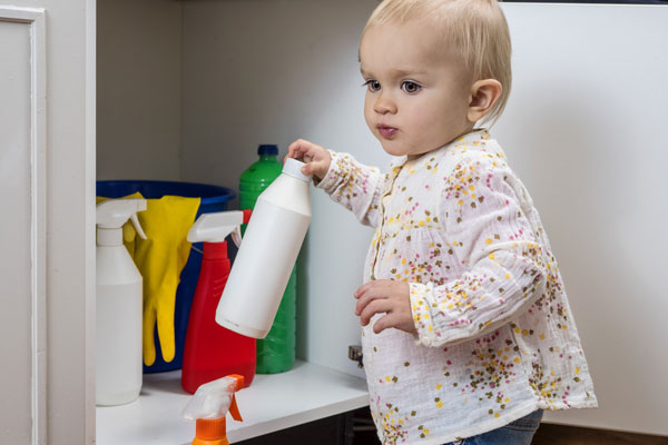 Kind holt Reinigungsmittel aus dem Schrank heraus