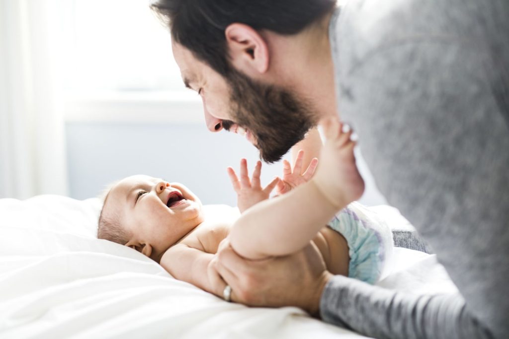 Papa und Baby beim Wickeln & Spielen