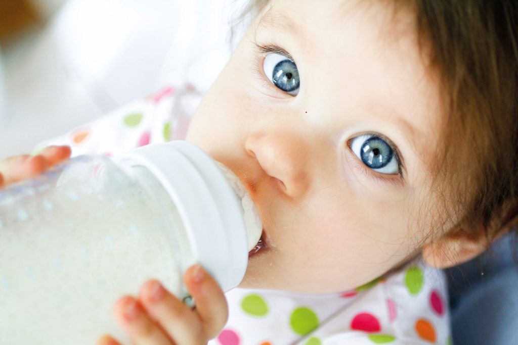 Baby trinkt aus Babyfläschchen